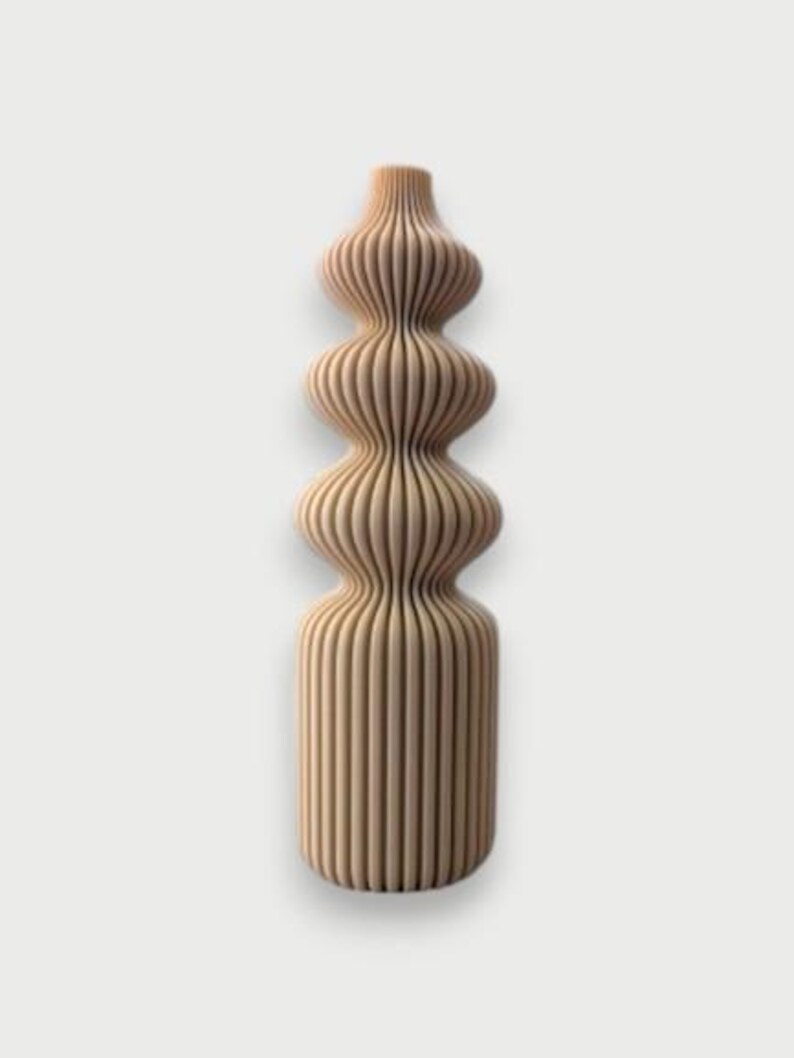 May include: A tall, decorative vase with a unique, layered design. The vase is made of light-colored wood and features a series of rounded, stacked sections, creating an organic, sculptural form. The vertical lines give it a textured appearance.