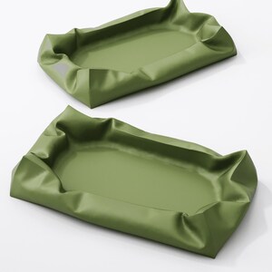 May include: Two olive green trays with a rectangular shape and a ruffled edge. The trays are empty and appear to be made of a smooth, possibly synthetic material. The background is white.