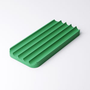 May include: A rectangular, green soap dish with four curved grooves. The dish has a textured, corrugated surface and is designed to hold soap bars. The bright green color adds a pop of color to any bathroom or kitchen.