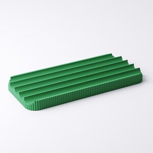 May include: A rectangular, green, ribbed tray. The tray has a series of parallel ridges running across its surface. The color is a vibrant, solid green. The tray is designed with a minimalist aesthetic.
