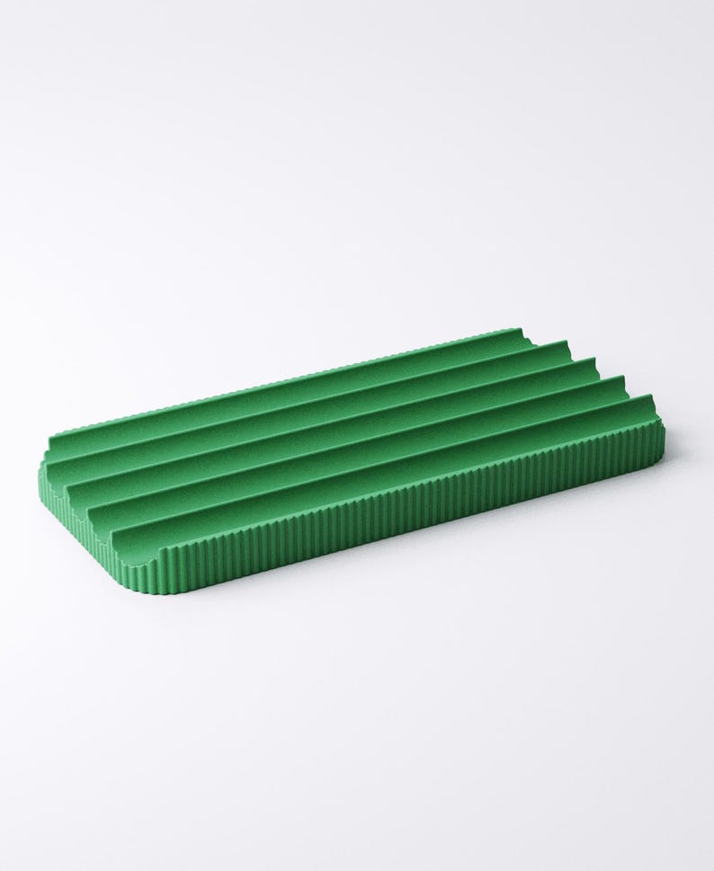 May include: A rectangular, green, ribbed tray. The tray has a series of parallel ridges running across its surface. The color is a vibrant, solid green. The tray is designed with a minimalist aesthetic.