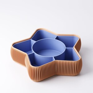 May include: A star-shaped organizer with a light brown, ribbed exterior and a blue interior. The organizer has a central circular compartment and several surrounding sections, ideal for storing small items. The design is modern and functional.