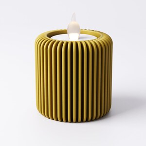May include: A yellow, cylindrical LED candle with a vertical ribbed design. The candle has a realistic, flickering flame effect. The candle is a decorative item for home decor.