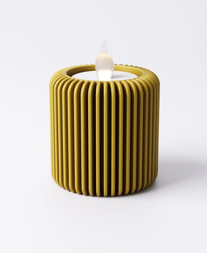 May include: A yellow, cylindrical LED candle with a vertical ribbed design. The candle has a realistic, flickering flame effect. The candle is a decorative item for home decor.