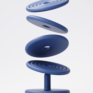 May include: A navy blue, modern chair with a circular base and a central support. The seat features concentric circles, with three additional circular elements floating above. The chair's design is minimalist and contemporary.