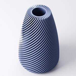 K&ouml;nnte beinhalten: Eine blaue Vase mit einem einzigartigen Design. Die Vase hat eine breite, offene Oberseite und einen abgerundeten, l&auml;nglichen K&ouml;rper. Die Au&szlig;enseite weist eine Reihe von gebogenen, horizontalen Linien auf, die eine strukturierte Oberfl&auml;che erzeugen. Die Vase besteht aus einem festen Material und hat eine glatte Oberfl&auml;che.