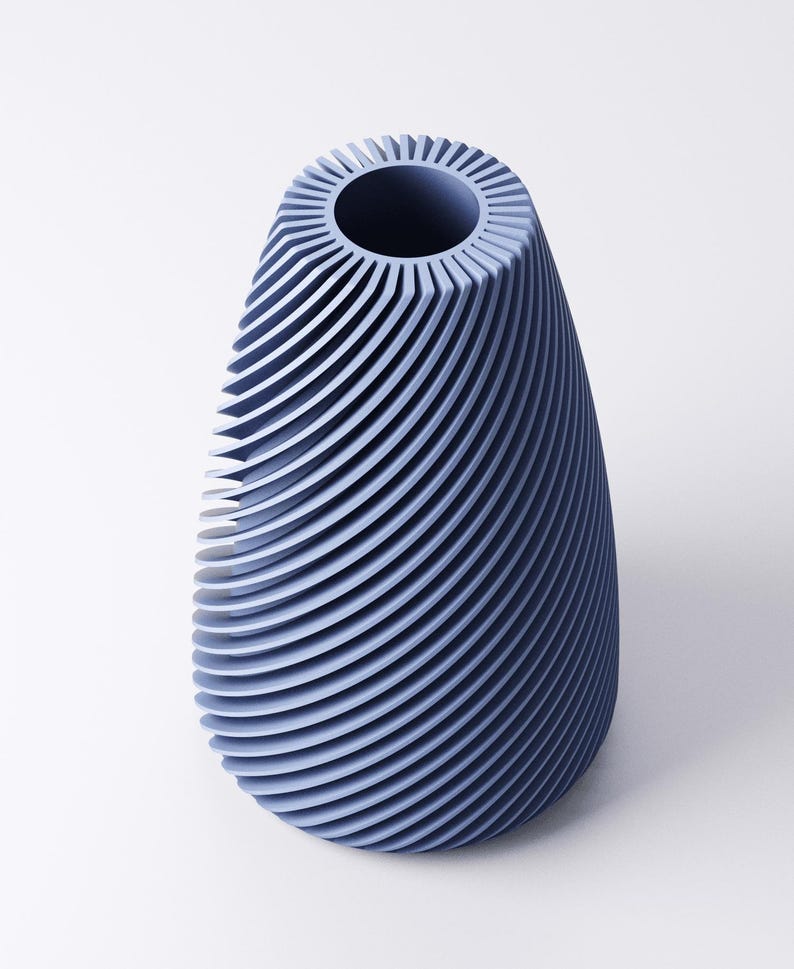 K&ouml;nnte beinhalten: Eine blaue Vase mit einem einzigartigen Design. Die Vase hat eine breite, offene Oberseite und einen abgerundeten, l&auml;nglichen K&ouml;rper. Die Au&szlig;enseite weist eine Reihe von gebogenen, horizontalen Linien auf, die eine strukturierte Oberfl&auml;che erzeugen. Die Vase besteht aus einem festen Material und hat eine glatte Oberfl&auml;che.