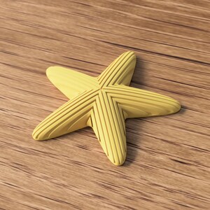 May include: A yellow starfish with a ridged design, resting on a wooden surface. The starfish has five points and a textured appearance. The background is a light brown wood grain.