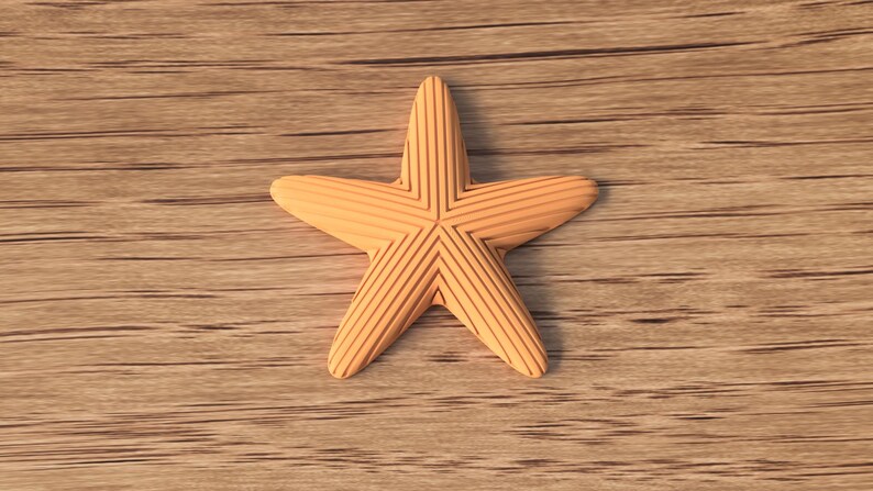 May include: A light orange starfish with etched lines, resting on a wooden surface. The starfish has five points and a detailed, textured design. The background is a light brown wood grain.