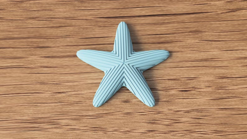 May include: A light blue starfish with textured lines, resting on a wooden surface. The starfish has five points and a detailed pattern. The background is a warm, light brown wood grain.