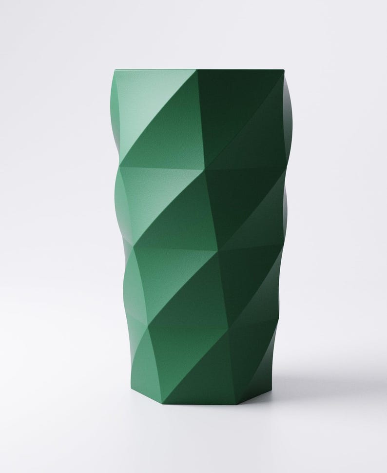 Op de afbeelding: Een hoge, geometrische vaas in een diepe bosgroene kleur. De vaas heeft een facetontwerp, met meerdere driehoekige en ruitvormige panelen die een textuur cre&euml;ren. De vaas is een modern decoratief item.