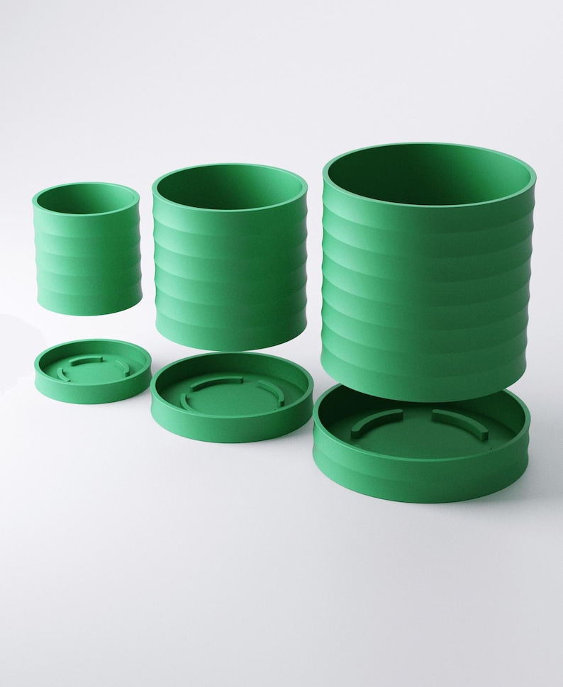 Op de afbeelding: Drie groene cilindrische containers met bijpassende deksels worden getoond tegen een witte achtergrond. De containers zijn van verschillende grootte, elk met horizontale geribbelde details. De deksels zijn cirkelvormig en passen perfect in de containers.