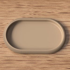 Puede incluir: Una bandeja ovalada beige con un borde acanalado. La bandeja est&aacute; vac&iacute;a y descansa sobre una superficie de madera. El dise&ntilde;o de la bandeja es simple y moderno, adecuado para servir o exhibir.