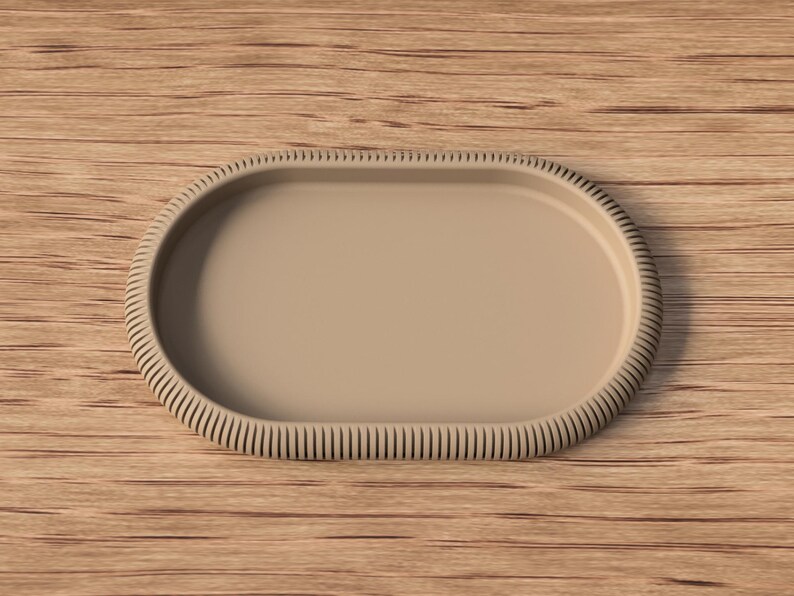 Puede incluir: Una bandeja ovalada beige con un borde acanalado. La bandeja est&aacute; vac&iacute;a y descansa sobre una superficie de madera. El dise&ntilde;o de la bandeja es simple y moderno, adecuado para servir o exhibir.
