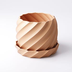 Może przedstawiać: Ceramiczna donica w kolorze terakoty ze spiralnym wzorem. Donica posiada pasujący spodek. Zewnętrzna strona posiada szereg ukośnych żeber, kt&oacute;re tworzą teksturowany, przyciągający wzrok wz&oacute;r. Projekt jest nowoczesny i minimalistyczny.