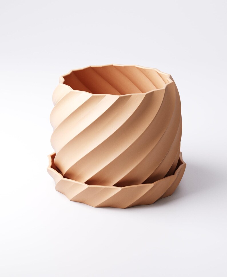 Może przedstawiać: Ceramiczna donica w kolorze terakoty ze spiralnym wzorem. Donica posiada pasujący spodek. Zewnętrzna strona posiada szereg ukośnych żeber, kt&oacute;re tworzą teksturowany, przyciągający wzrok wz&oacute;r. Projekt jest nowoczesny i minimalistyczny.