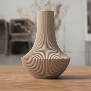 May include: A beige, ribbed vase with a wide base and a slender neck. The vase has a textured, vertical striped pattern. It is sitting on a wooden table, with a blurred background.