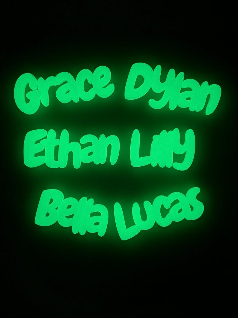 May include: Bright green, glowing names against a black backdrop. The names "Grace Dylan", "Ethan Lilly", and "Bella Lucas" are written in a whimsical font. Suitable for personalised room decorations or presents.