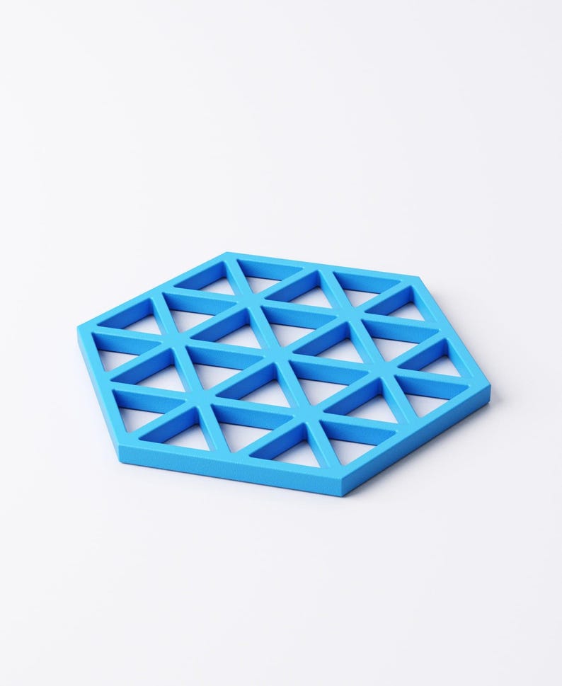 Pu&ograve; includere: Un sottobicchiere blu brillante a forma esagonale con un design geometrico. Il sottobicchiere presenta un motivo triangolare ripetuto. &Egrave; realizzato in un materiale solido e si trova su uno sfondo bianco. Circa 15 cm di diametro.