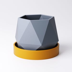 May include: A geometric, gray planter with a faceted design sits atop a bright yellow saucer. The planter has a hexagonal opening and a modern, minimalist aesthetic. This decorative piece is suitable for small plants or succulents.