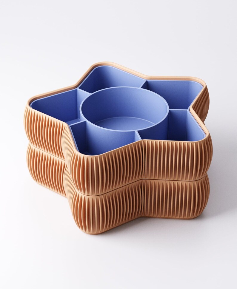 May include: A star-shaped storage container with a light brown exterior and a blue interior. The container is divided into multiple compartments, including a central circular section. The exterior has a ribbed design.