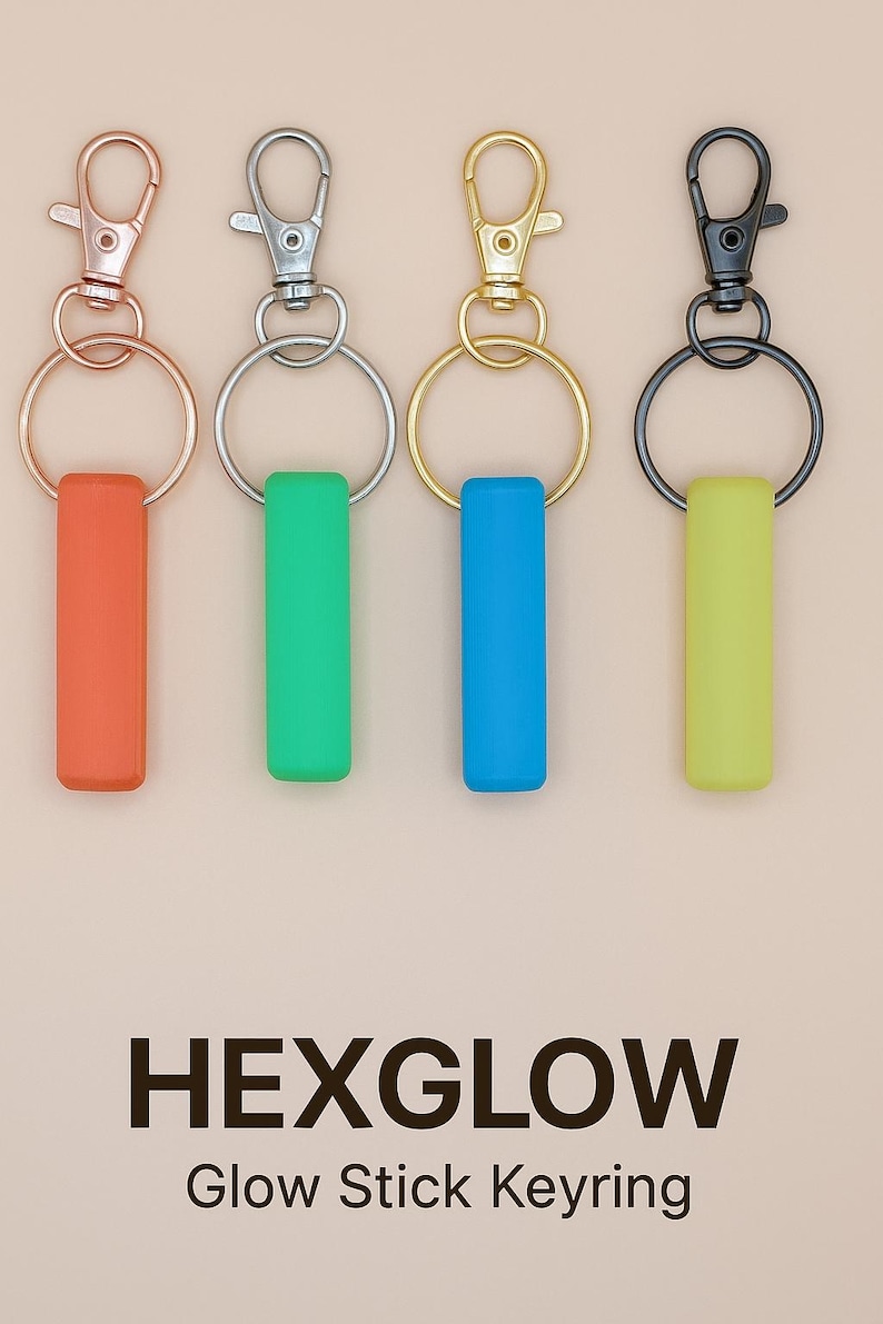 May include: Four keychains with colorful glow stick-shaped pendants. The keychains have different metal finishes: rose gold, silver, gold, and black. The pendants are orange, green, blue, and yellow. The text "HEXGLOW Glow Stick Keyring" is at the bottom.