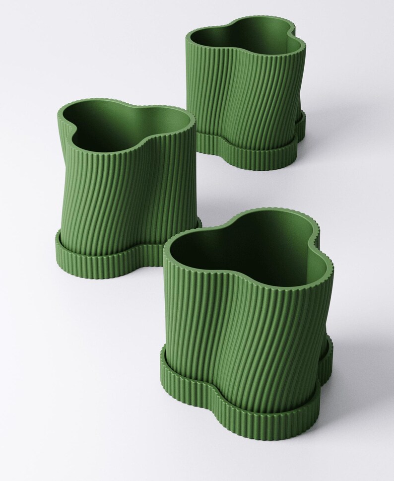May include: Three green plant pots with a wavy top edge and a ridged, vertical design. Each pot sits on a matching, scalloped base. The pots are arranged on a white background.