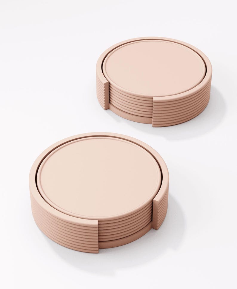 Peut inclure: Deux ensembles de dessous de verre ronds de couleur blush. Chaque ensemble comprend une pile de dessous de verre avec un dessus circulaire et un bord rainur&eacute;. Les dessous de verre sont con&ccedil;us pour contenir des verres et prot&eacute;ger les surfaces des traces d'eau.