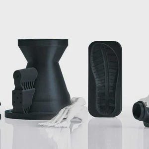 May include: A collection of 3D-printed objects in black and white. The objects include a Y-shaped structure, a cylindrical piece with a spiral design, a claw-like shape, a shoe sole imprint, and a cross-shaped frame. The objects are displayed on a reflective surface.