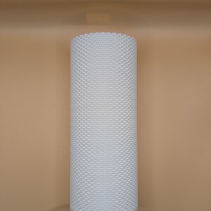 K&ouml;nnte beinhalten: Eine wei&szlig;e zylindrische Lampe mit einer strukturierten, gepunkteten Oberfl&auml;che. Die Lampe hat einen soliden Sockel und ein Netzkabel. Der Hintergrund ist einfarbig beige. Die Lampe ist ein modernes Design.