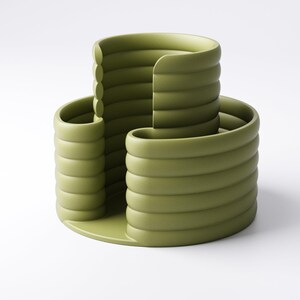 Może przedstawiać: Nowoczesny, oliwkowozielony ceramiczny wazon o unikalnym, warstwowym designie. Wazon posiada okrągłą podstawę i trzy zakrzywione sekcje, każda z poziomymi żebrami. Abstrakcyjna, rzeźbiarska forma nadaje się do dekoracji wnętrz.