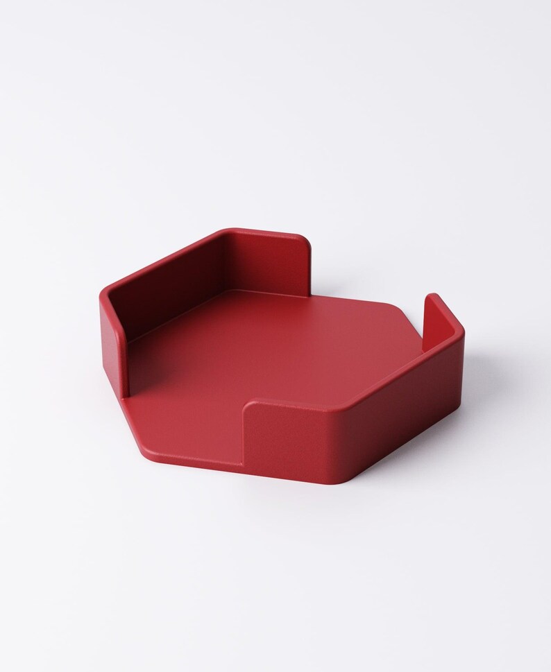 May include: A solid red, hexagonal desk tray with raised sides. The tray has a minimalist design and is likely made of a durable material. The tray is designed to hold small items and keep a desk organized.
