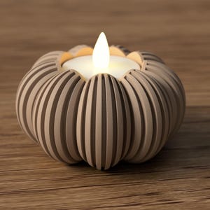 May include: A beige, pumpkin-shaped candle holder with vertical grooves. The candle holder has a white candle with a flickering flame. The candle holder is on a wooden surface.