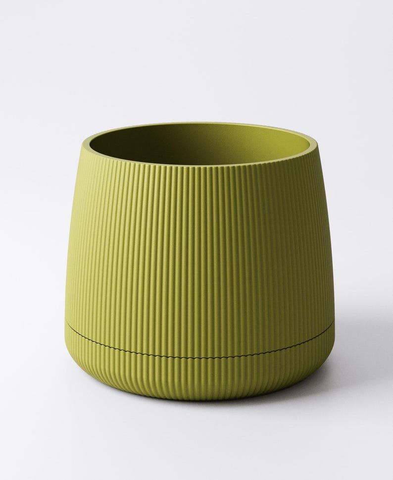 May include: A chartreuse-colored, ribbed planter with a cylindrical shape. The planter has a slightly flared top and a black line encircling the base. The vertical ribs create a textured surface.