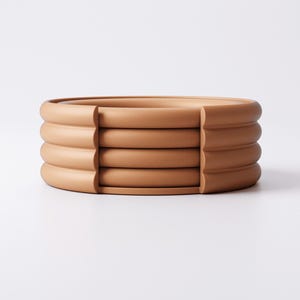 Puede incluir: Un conjunto de cuatro posavasos redondos de cer&aacute;mica color terracota. Cada posavasos tiene un borde redondeado y estriado. Los posavasos est&aacute;n apilados, con un peque&ntilde;o espacio entre cada uno. Fondo blanco. Miden aproximadamente 12 cm de di&aacute;metro.