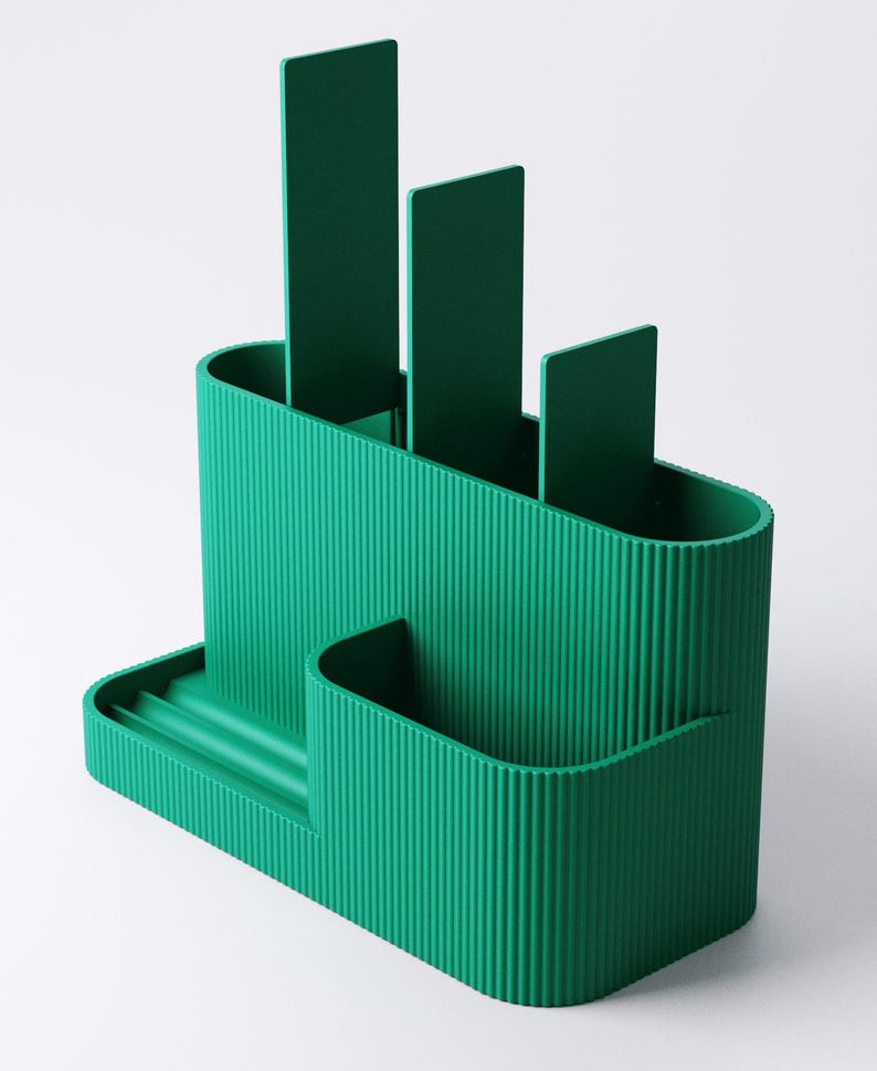 Pode incluir: Um organizador de secret&aacute;ria verde-azulado com uma textura canelada. O organizador tem v&aacute;rios compartimentos, incluindo ranhuras para canetas ou l&aacute;pis e uma bandeja pequena. O design inclui tr&ecirc;s divisores verticais e uma forma arredondada.
