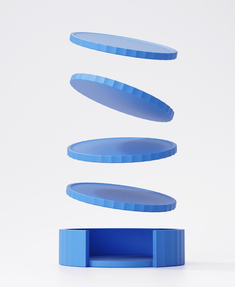 May include: A blue, geometric, modern design featuring a cylindrical base with a circular interior and four floating, circular, blue discs. The discs have a ridged edge. The design is set against a white background.