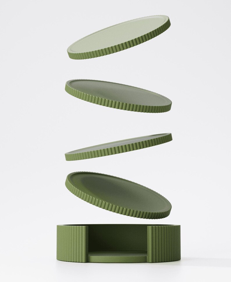 May include: A set of four olive green, oval-shaped trays and a matching base. The trays have a ridged edge and appear to be floating above the base. The base is a rectangular box with a matching ridged design. The background is plain white.