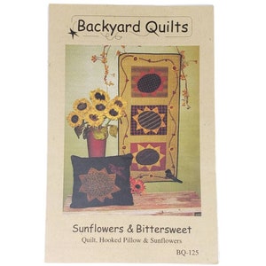 Peut inclure: Un modèle de courtepointe, d'oreiller à crochet et de tournesols. Le modèle présente une courtepointe avec trois carrés, chacun avec un motif de tournesol différent. Le modèle est intitulé "Sunflowers & Bittersweet" et porte le numéro BQ-125.