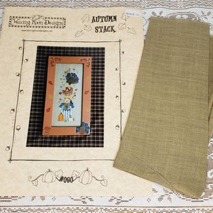 May include: A cross-stitch pattern for a fall-themed design called "Autumn Stack" by Waxing Moon Designs. The pattern features a scarecrow, pumpkins, and a turkey. The pattern number is #080.