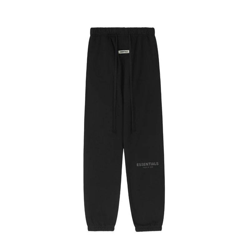 May include: Black sweatpants with a drawstring waist and the word "ESSENTIALS" printed on the left leg. The pants have a relaxed fit and a small rectangular tag near the drawstring.