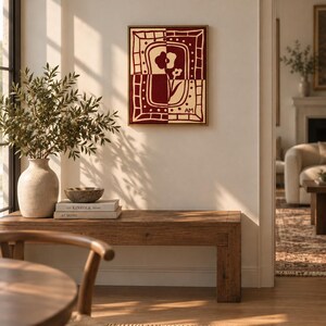 Puede incluir: Una pieza de arte mural rectangular con un dise&ntilde;o de panel dividido en rojo oscuro y crema. La obra muestra motivos florales estilizados dentro de un borde decorativo, con las iniciales AM visibles en la esquina inferior derecha, en un marco.