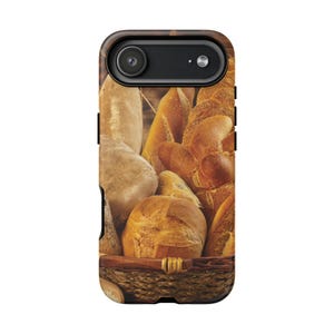 May include: A rectangular smartphone case featuring a high-resolution photographic print of various golden-brown artisan breads piled inside a woven wicker basket. The design covers the entire back surface, showcasing textures of crusty loaves.