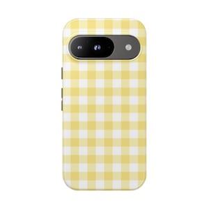 May include: A yellow and white gingham pattern phone case. The case has a camera cutout and buttons on the side. The case is designed to fit a smartphone.