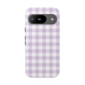 May include: A lavender and white gingham patterned phone case. The case has a rectangular shape with rounded corners and a camera cutout at the top. The case is designed for a Google Pixel phone.