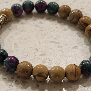 May include: A bracelet made of brown and green gemstone beads with a gold metal clasp.