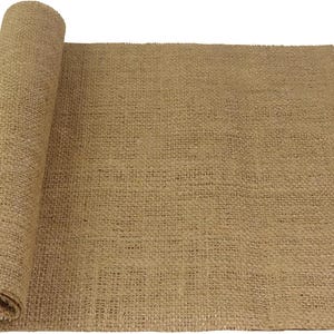 May include: A roll of natural burlap fabric, partially unrolled, displaying a coarse, woven texture. The fabric is a warm, earthy brown color, suitable for rustic crafts and decor. The roll is on a white background.