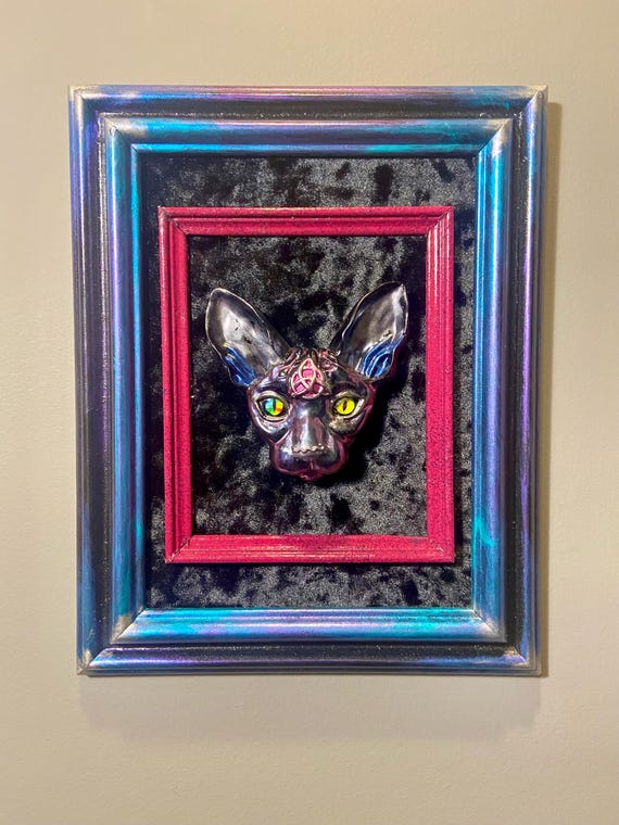 A one-of-a-kind framed 3D resin Sphynx cat head wall piece — darkly hilarious, handmade, and the exact kind of thing that makes a room.