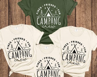 May include: Four t-shirts with a camping theme. One is olive green, the others are cream-colored. Each shirt has a black graphic with the words "FIRES, FRIENDS, FUN, CAMPING crew" and a tent design.