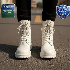 May include: White lace-up boots with a chunky sole. The boots have a side zip and are made of a smooth material. The boots are shown from the ankles down, with the laces tied.
